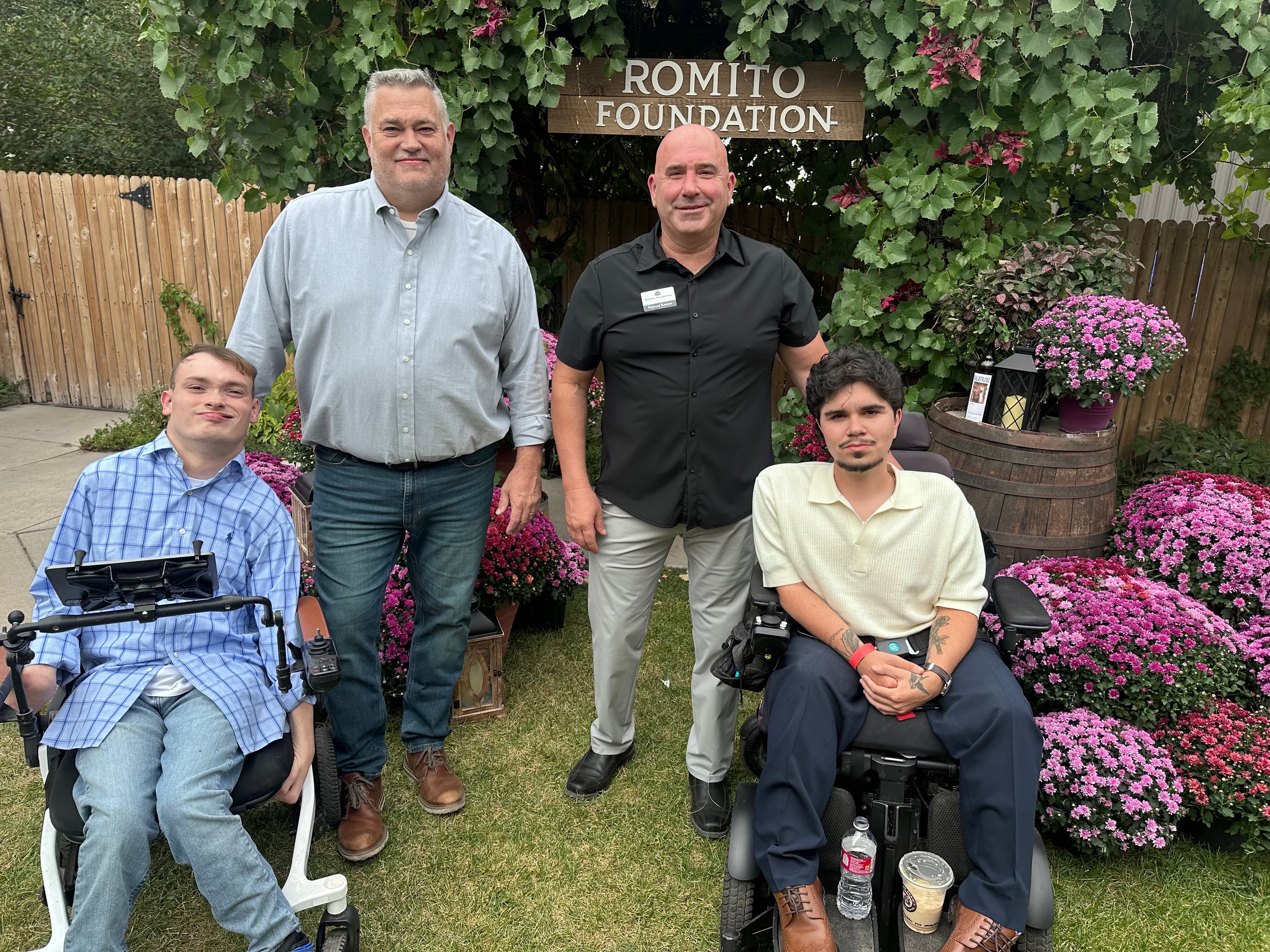 Richard Romito, Dom Romito, and Rolling Rapids athletes at the Romito Foundation sign in the Balistreri Vineyard garden